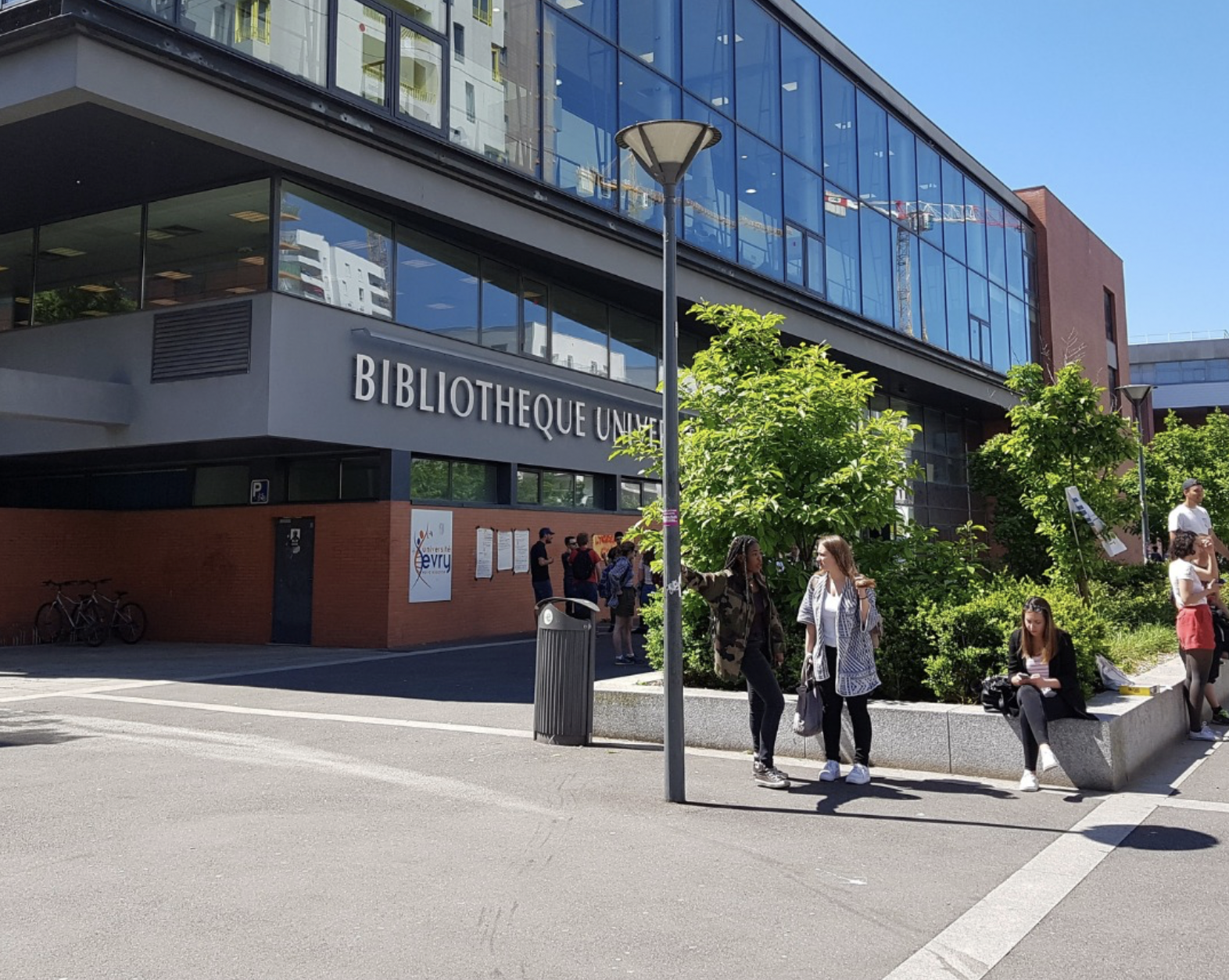 Universite d'Evry Paris-Saclay library building with students outside